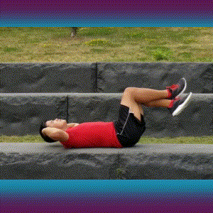 A man doing crunches on the grass.