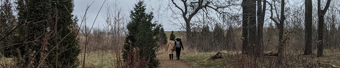 Two people in winter jackets walking through Boake's Grove.