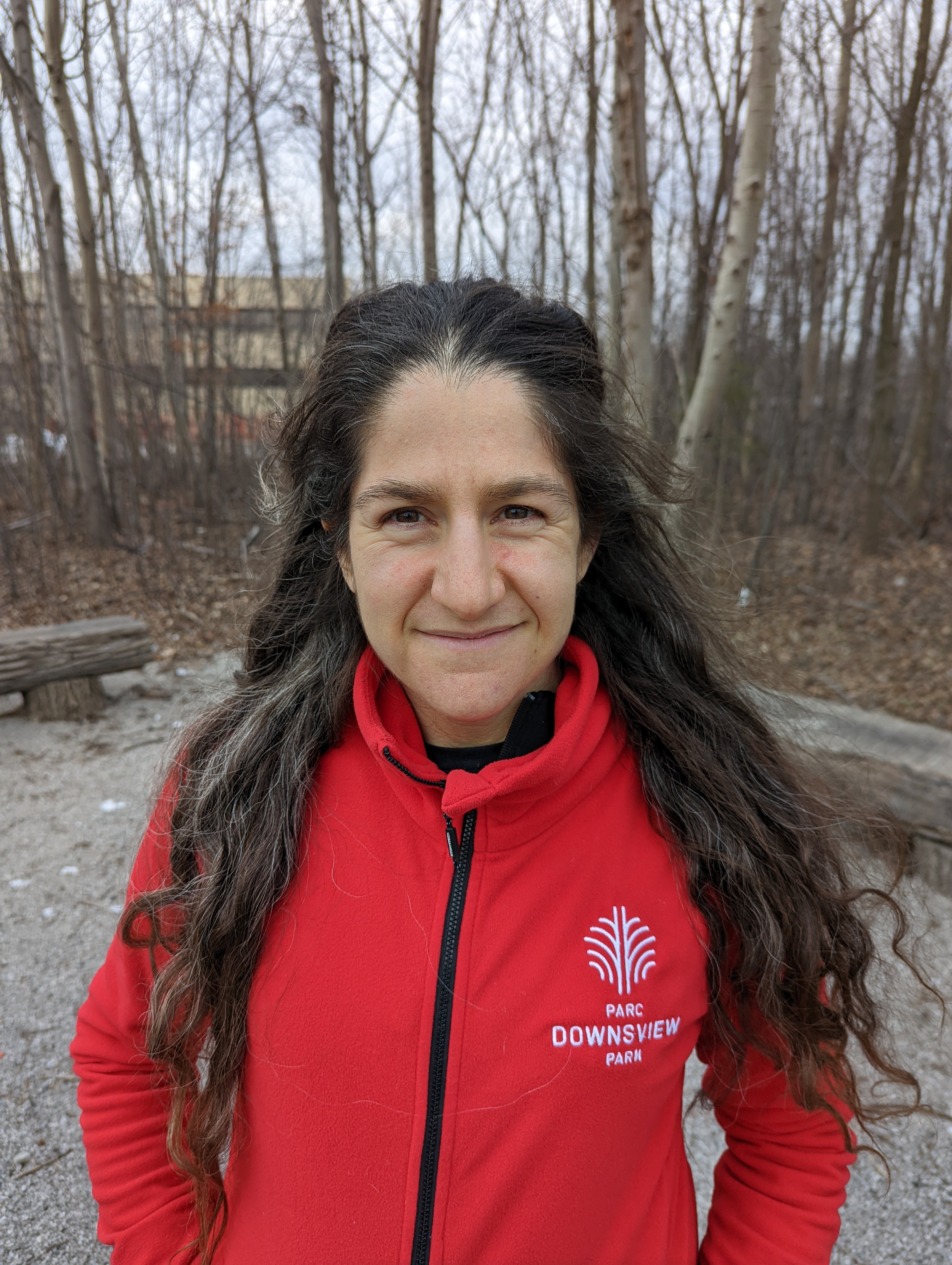 Allison smiling for the camera in a red staff jacket.