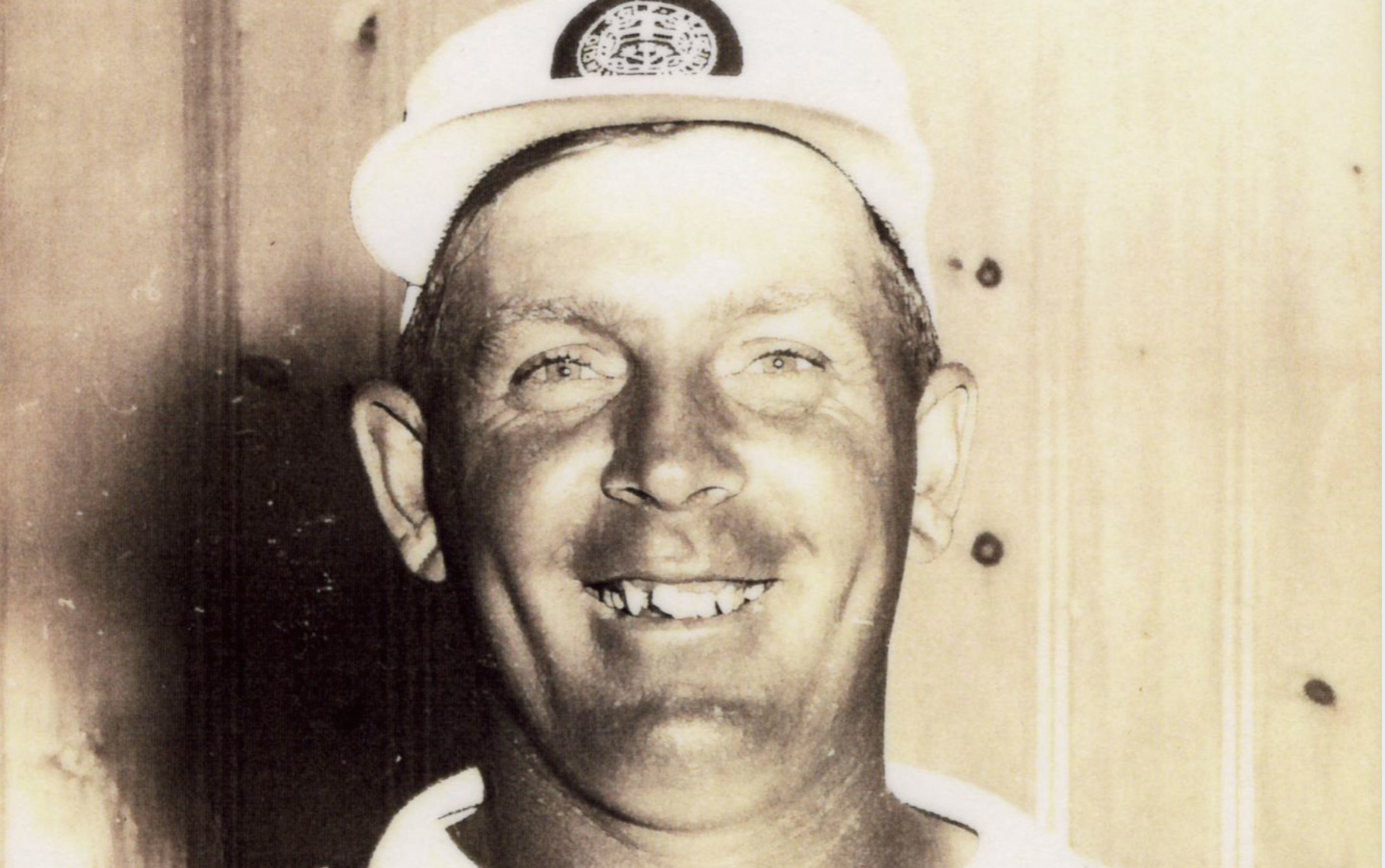 A black and white photo of a smiling Moe Norman.