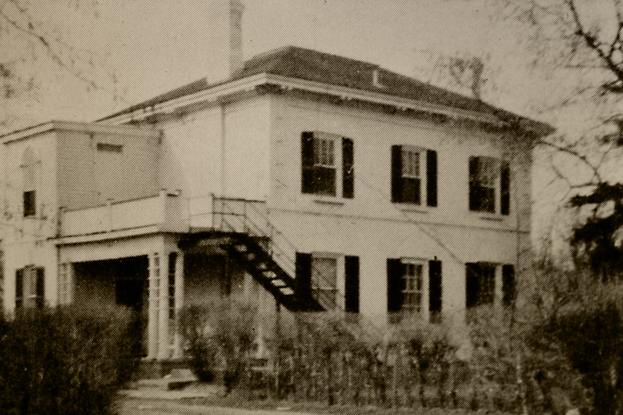 A black and white photo of a large house.