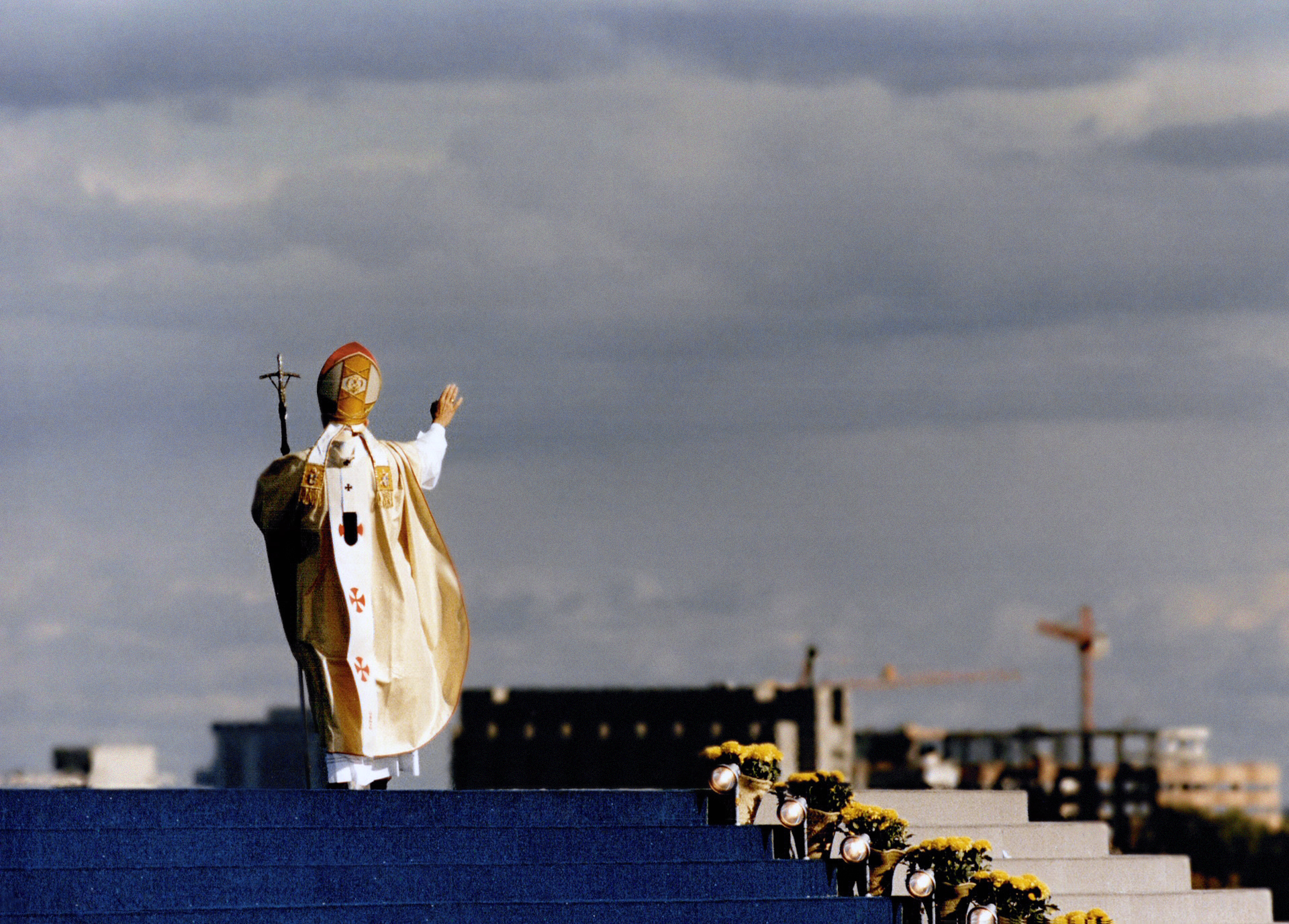 The Pope waving from a platform.