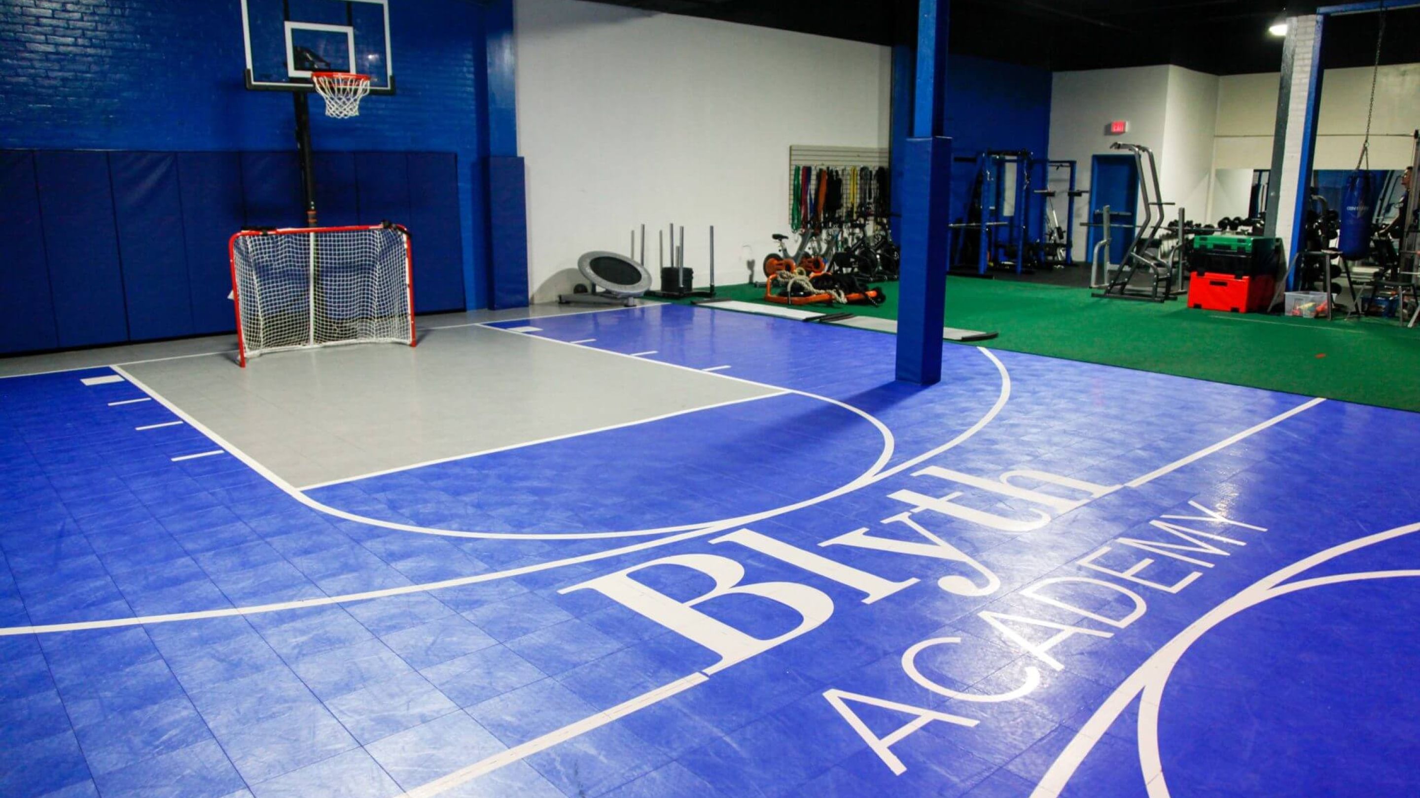 An indoor basketball court and weight training equipment.