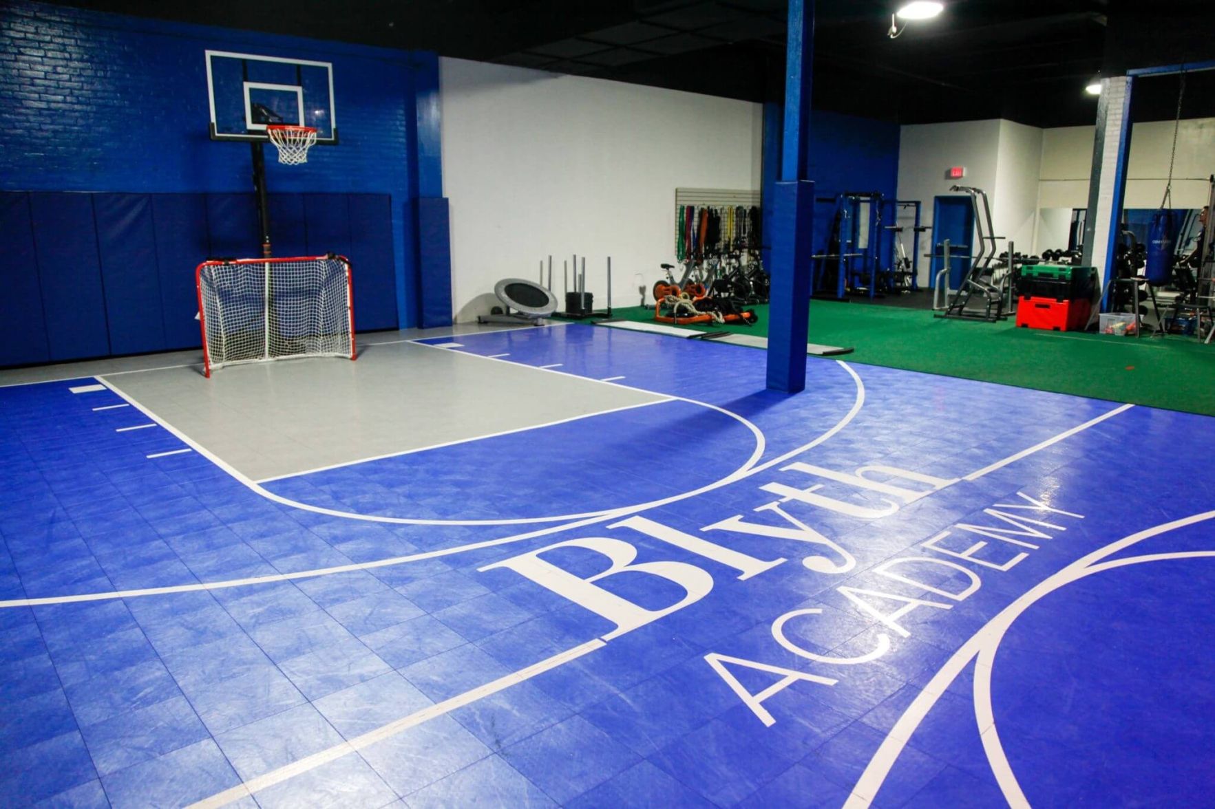 An indoor basketball court and weight training equipment.