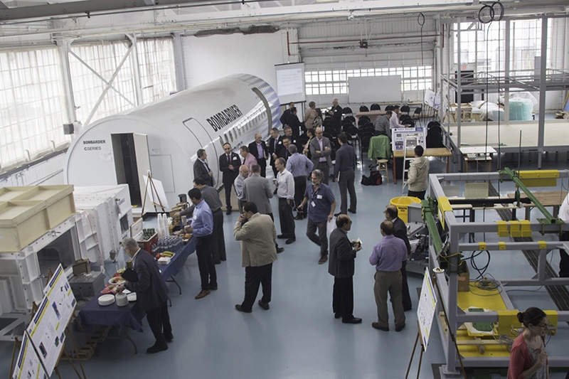 Staff and students gathered indoors around part of a Bombardier aircraft.