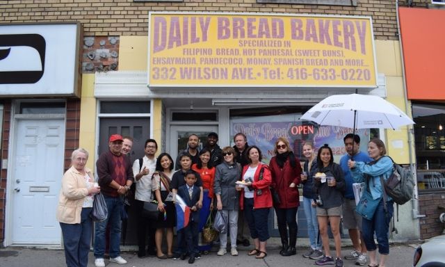A group of people in front of a bakery on a tour of Little Manila.