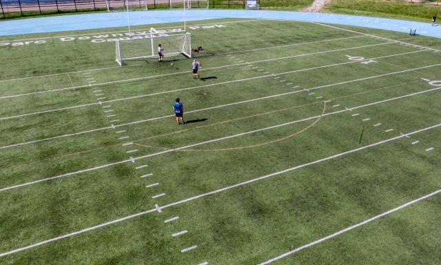 An aerial shot of people playing soccer on a field.
