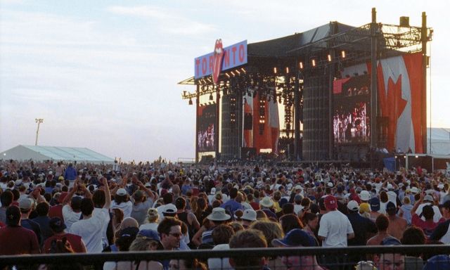 A large crowd of people in front of a massive stage.