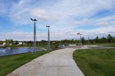 Model planes along a paved path that overlooks a body of water.