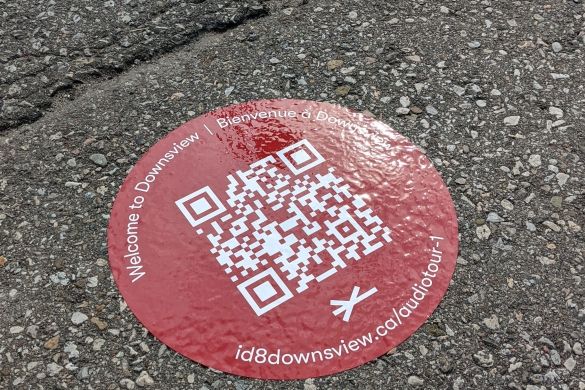 A QR code sticker on a paved path.
