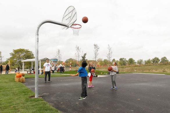 Three kids playing at the basketball court.