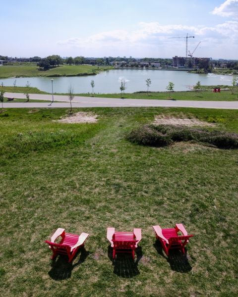three muskoka chairs by the lake