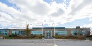 A brown building with blue windows along Carl Hall Road.